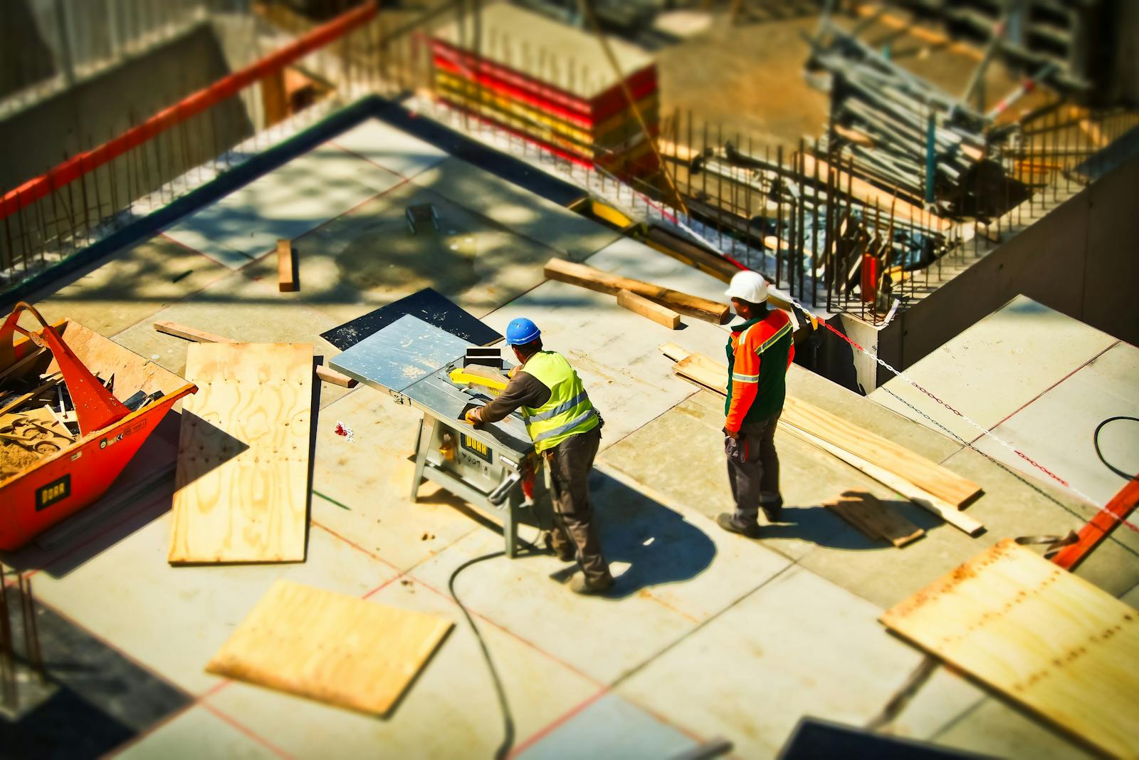 contractors, Construction workers engaging in tasks at an outdoor building site with safety hats and equipment.